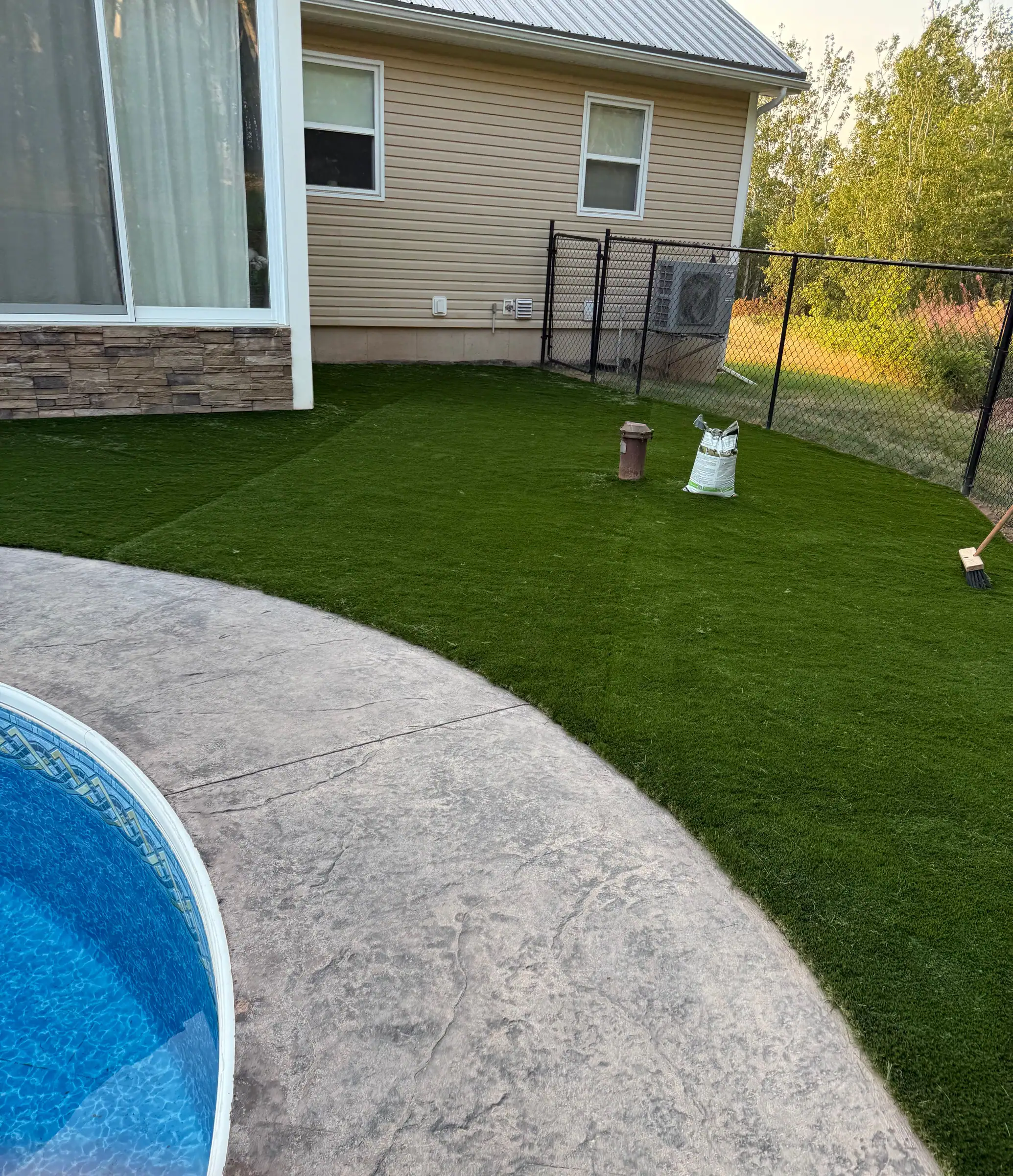 After: synthetic turf laid right up to the stamped-concrete edge of the pool